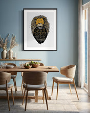 Load image into Gallery viewer, Artwork in a black frame with the with a white matte. The frame is on a wall above a dining table. The artwork features an illustrated Aslan (the lion from Chronicles of Narnia). Inside the lion the Narnia quote is featured reading “At The Sound of Your Roar, Sorrows Will Be No More.”