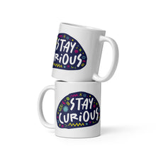 Load image into Gallery viewer, Two white mugs stacked on top of each other.  The mug features a design with the words &#39;stay curious&#39; in an illustrated oval shape with sketchy elements around it. 