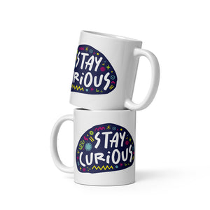 Two white mugs stacked on top of each other.  The mug features a design with the words 'stay curious' in an illustrated oval shape with sketchy elements around it. 