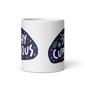 A side view of a white mug on a white background. The mug features a design with the words 'stay curious' in an illustrated oval shape with sketchy elements around it. 