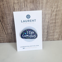 Load image into Gallery viewer, An enamel pin with the words &quot;Stay curious&quot; featured on the card backing you receive with mailed to you.