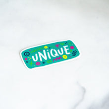 Load image into Gallery viewer, A vinyl die cut sticker with the word &quot;unique&quot; and sketchy elements surrounding the word. 