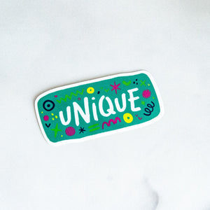 A vinyl die cut sticker with the word "unique" and sketchy elements surrounding the word. 