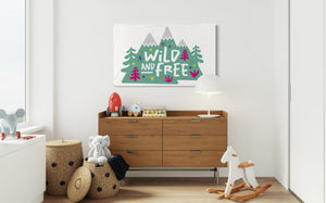 A large white flag featured on a wall of a kids' bedroom. The white flag features the words 'wild and free' inside illustrated mountains with sketch trees and other elements around.