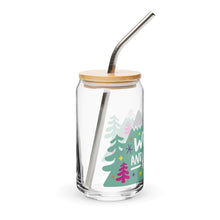 Load image into Gallery viewer, A photo of a glass can tumbler on a white background showing the side of the glass. The glass tumbler has a bamboo lid and silver metal straw. The design on the glass tumbler says the words &quot;wild and free&quot; inside illustrated mountains with sketchy trees around. 