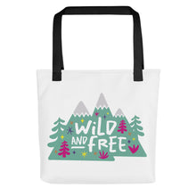 Load image into Gallery viewer, A white tote bag with black handles on a white background. The tote bag has the design with the words &#39;wild and free&#39; with the words inside illustrated mountains with illustrated trees around the words. 