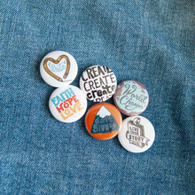 Load image into Gallery viewer, A set of six buttons on a jean jacket. The buttons feature word art illustrations with the words &quot;Live Your Story,&quot; &quot;Don&#39;t Give Up,&quot; &quot;Faith Hope Love,&quot; &quot;Create,&quot; &quot;Write,&quot; and &quot;World Changer.&quot;