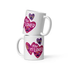 Load image into Gallery viewer, Two white mugs stacked on top of each other. The mug features a design with the words &#39;you are so loved&#39; inside two illustrated pink hearts with a purple heart above it. 