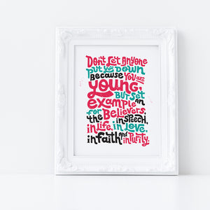 A print featured in a white frame with the lettering in red, blue and black. The Bible verse reads "Don't let anyone put you down because you are young, but set an example for the believers, in speech, in life, in love, in faith and in purity."