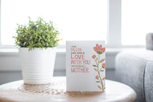 Load image into Gallery viewer, A greeting card is featured on a desktop with a green plant in the background. The card features illustrated flowers on the right hand side of the card. The petals are muted pink and the stem and leaves are green and light brown. To the left of the flowers the card reads &quot;I have fallen more in love with you since you became a mother.&quot; 