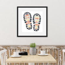 Load image into Gallery viewer, Artwork featured on a kitchen wall with a black frame. The artwork features illustrated footpritns in black with the words in grey, yellow and orange. The words read &quot;The Lord makes firm the steps of the one who delights in him. Though he may stumble, he will not fall, for the Lord upholds him with his hand.&quot;