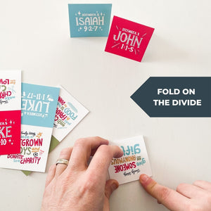 A photo of the cards and hands folding one of the cards with the words "fold on the divide."