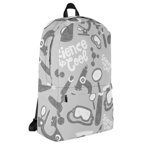 A backpack featured with a white background showing the side of the backpack. The backpack is a light gray with a pattern of illustrations in darker gray and white. The pattern of illustrations features test tubes, microscopes, magnifying glasses, protective science goggles, atom models and the words "Science is cool."