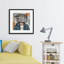 Load image into Gallery viewer, A black frame on a wall above a yellow sofa. The frame features a vintage boombox as a head on a person dressed in a shirt and a hoodie. 