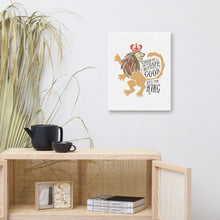Load image into Gallery viewer, A white canvas hanging above a shelf with a plant beside it. The artwork features hand drawn illustration of the Chronicles of Narnia lion character Aslan. Inside the illustration there is the quote &quot;Course He Isn&#39;t Safe, But He&#39;s Good. He&#39;s the King.&quot;