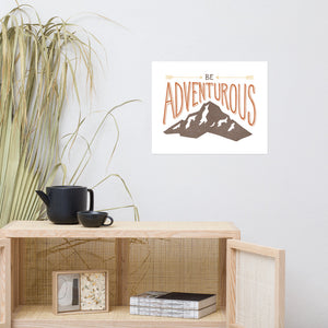 A canvas on the wall above a shelving unit. The artwork on the canvas has the words “Be adventurous” with arrows pointing to the word “be” and a brown mountain illustration underneath the word “adventure.”