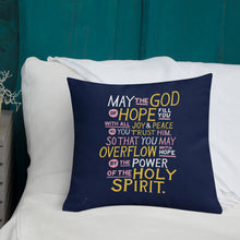 Load image into Gallery viewer, A pillow on a bed with the Bible verse &quot;May the God of hope fill you with all joy and peace as you trust him, so that you may overflow with hope by the power of the holy spirit.&quot; The pillow is purple with lettering in white, pink and yellow. 