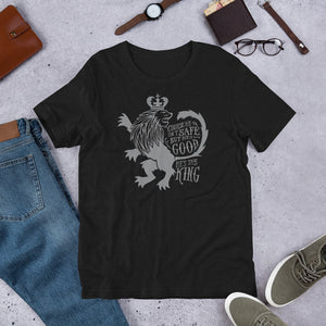 A black short sleeved T-shirt laying flat with objects around it. The T-Shirt features hand drawn illustration of the Chronicles of Narnia lion character Aslan. Inside the illustration there is the quote "Course He Isn't Safe, But He's Good. He's the King."