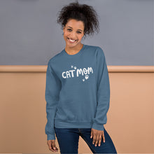 Load image into Gallery viewer, A indigo blue sweatshirt featuring the phrase Cat Mom in white lettering with white heart shaped paws around the words. 