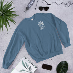A indigo blue sweatshirt laying with jeans and shoes. The indigo blue sweatshirt features the word "create, create, create, create, create" in white in a small rectangle on the upper left side.