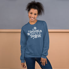 Load image into Gallery viewer, A woman wearing a indigo blue sweatshirt featuring hand drawn lettering with the words &quot;Dashing through the snow&quot; in white. There are snowflakes around the words. 
