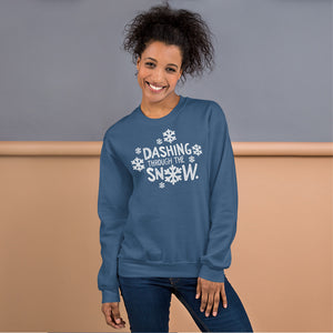 A woman wearing a indigo blue sweatshirt featuring hand drawn lettering with the words "Dashing through the snow" in white. There are snowflakes around the words. 