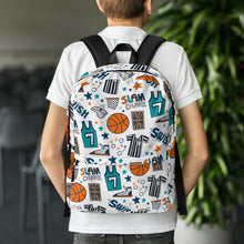 Load image into Gallery viewer, A boy with his back to the camera and dining chairs and a plant in the distance. The boy is wearing a white short sleeved polo shirt with a backpack on his shoulders. The backpack has a white background with a basketball themed pattern backpack featuring illustrated basketballs, basketball jerseys, whistles, referee shirts, basketball hoops, stars, basketball shoes, fun play sketches and the word &quot;swish.&quot; The backpack straps are black. 