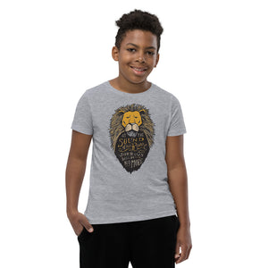 A boy wearing a light grey short sleeved T-Shirt. The T-Shirt features hand drawn illustration of the Chronicles of Narnia lion character Aslan. Inside the illustration there is the quote “At The Sound of Your Roar, Sorrows Will Be No More.”