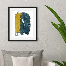 Load image into Gallery viewer, A black frame above a sofa with a plant off to the side. The frame features illustrated artwork of a buffalo in blue and yellow.