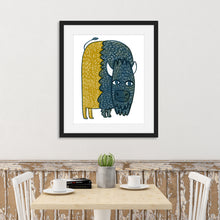 Load image into Gallery viewer, A black frame above a kitchen table. The frame features illustrated artwork of a buffalo in blue and yellow.