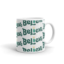 Load image into Gallery viewer, A white ceramic mug featured on a white background. The mug has a repeat pattern of the word Believe in green. The &quot;I&quot; of Believe is an illustrated Christmas tree. 