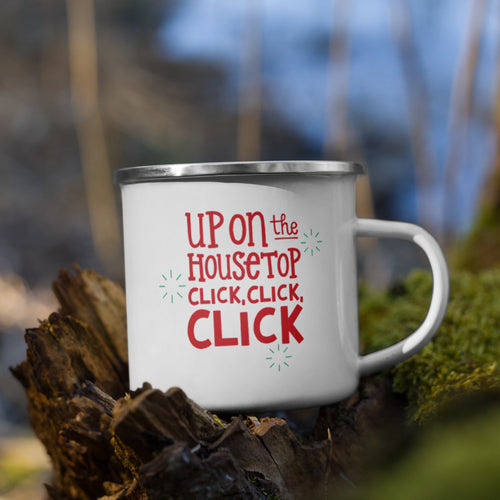White enamel mug sitting on top of a tree branch with moss in the background. The design on the mug is featured in red reading 