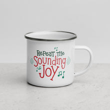 Load image into Gallery viewer, White enamel mug featured on a white table top and white background. The design is in red and green with music notes around the words reading &quot;Repeat the Sounding Joy.&quot; 