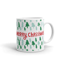 Load image into Gallery viewer, A white ceramic mug featured on a white background. The mug features a pattern of illustrated pine trees in dark and light green. The words Merry Christmas are in the middle in red. 