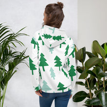 Load image into Gallery viewer, A woman wearing a white hoodie showing how the back of the hoodie look and the back of the hoodie. The hoodie features a pattern of illustrated pines trees in dark and light green on the white hoodie. 