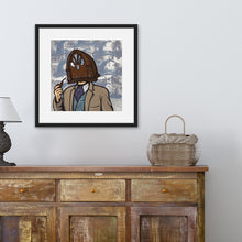 Load image into Gallery viewer, A black frame above a a brown dresser featuring an illustration of a vintage radio as a &quot;head&quot; of a person in a suit who is smoking a pipe.
