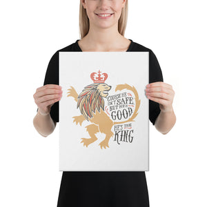 A woman holding a white canvas in her hands. The artwork features hand drawn illustration of the Chronicles of Narnia lion character Aslan. Inside the illustration there is the quote "Course He Isn't Safe, But He's Good. He's the King."