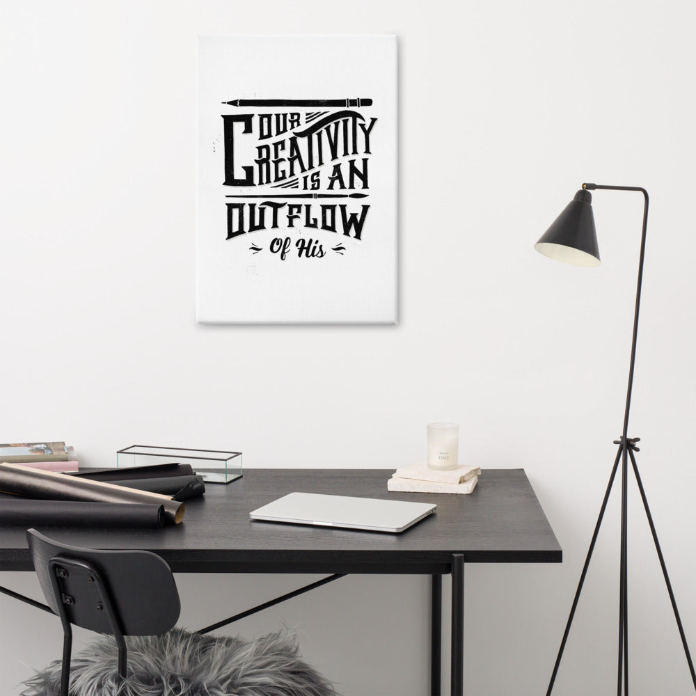 A canvas on a wall above a desk. The canvas is white and features hand drawn lettering featuring 