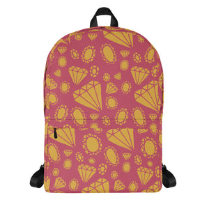 A backpack featured with a white background. The backpack features illustrated gems and diamonds in gold on top off a muted hot pink colored backpack. The straps are black. 