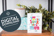 Load image into Gallery viewer, A greeting card is on a table top with a present in blue wrapping paper in the background. On top of the present is a candle and some greenery from a plant too. The card features the words “You are my super hero mom.” The words &quot;digital download&quot; are featured in a circle on top of the image. 