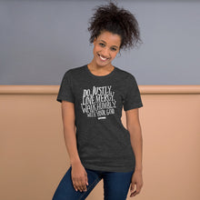 Load image into Gallery viewer, A woman wearing a dark grey T-shirt with the words Do justly, love mercy, walk humbly, with your God and Micah 6:8 at the bottom. The lettering is in white on the grey shirt. 