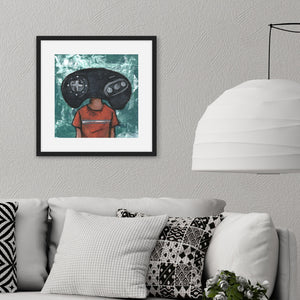 A black frame above a grey sofa. The artwork in the frame is an illustration of an original Sega Genesis controller as someone's "head." 