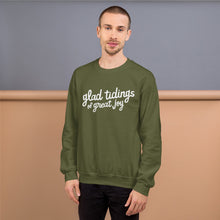Load image into Gallery viewer, A man wearing a green sweatshirt featuring hand drawn lettering with the words &quot;glad tidings of great joy&quot; in white. 
