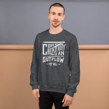 Load image into Gallery viewer, A man wearing a dark grey sweatshirt featuring hand drawn lettering in white with the words &quot;Our creativity is an outflow of His.&quot;