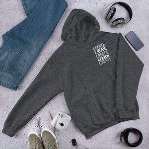 A dark grey hoodie featuring the word "create, create, create, create, create" in white in a small rectangle on the upper left side.