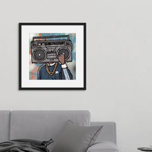 Load image into Gallery viewer, A black frame on a wall above a grey sofa. In the frame is an illustrated image of a boombox with a person wearing a gold chain and blue jacket. 