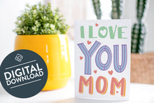 Load image into Gallery viewer, A greeting card is on a table top with a yellow plant pot and a green plant inside. The card features the words “I love you Mom.” The words &quot;digital download&quot; are featured in a circle on top of the image. 
