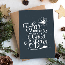 Load image into Gallery viewer, A photo of a Christmas card on top of a brown paper wrapped gift with Christmas decor around it. The Christmas card has a navy color as the background with white words reading &quot;for unto us a child is born.&quot; Above the words is an illustrated Bethlehem star and below the words is a small illustration of the city of Bethlehem.