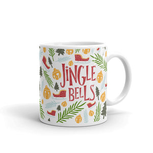 A white ceramic mug featured on a white background. The mug features a pattern of Christmas illustrations of leaves, pine trees, ornaments and sleighs. The illustrations are in yellow, light blue, light and dark green. The words "Jingle Bells" are in red. 