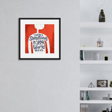 Load image into Gallery viewer, A red print in a black frame hangs on a light grey living room wall. The print features the outline of a person in white, filled with light grey doodles. The words ‘There’s something in you the world needs&#39; are lettered in black across the person’s chest. In the background there are white bookshelves holding books and ornaments.